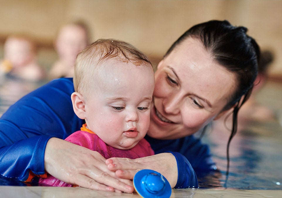 water babie teacher and baby in hold on position