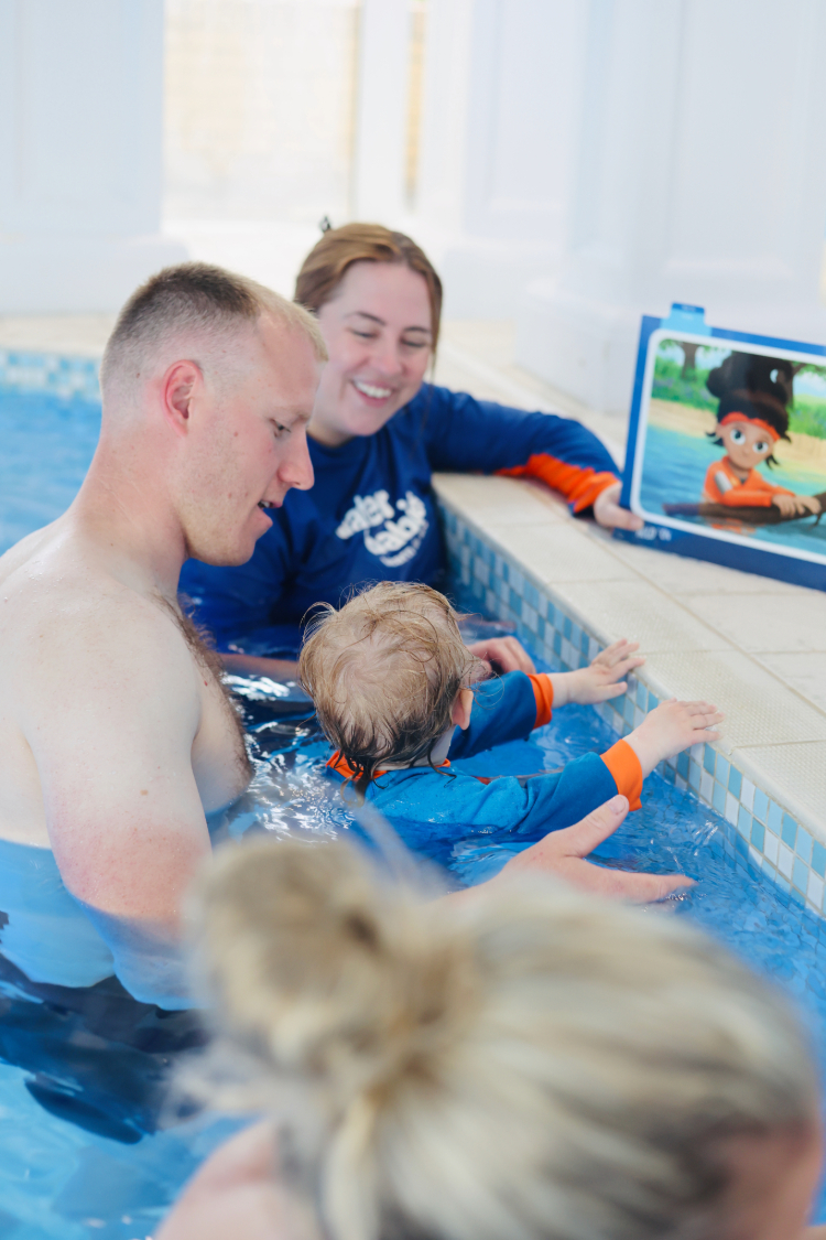water babies teacher with carer and toddler in hold on position