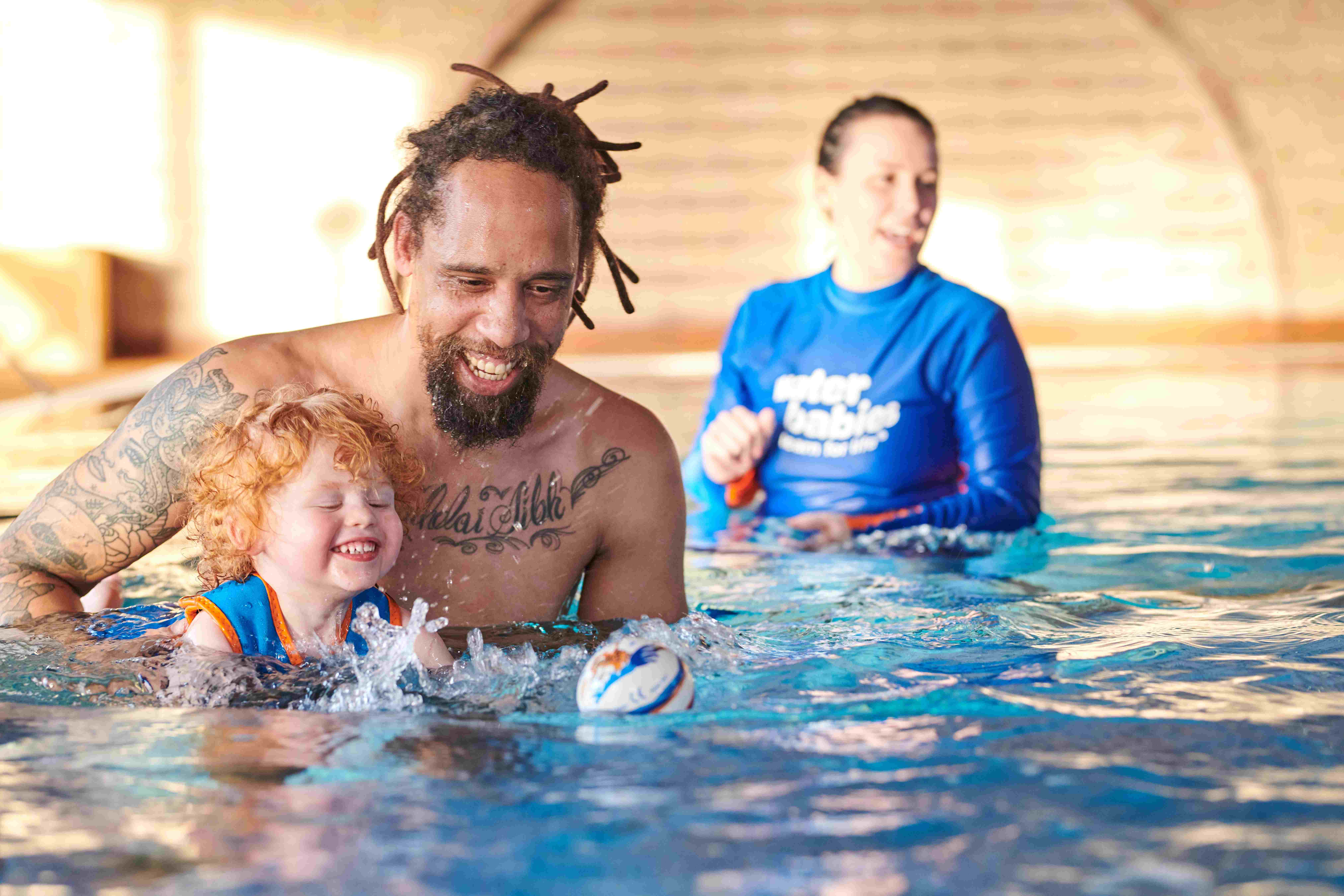 dad with toddler and water babies teacher