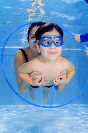 mum and toddler swimming through a hoop underwater 