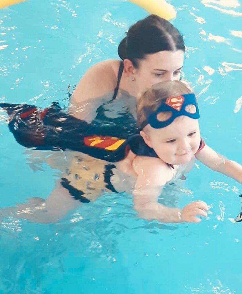 water babies teacher laura swimming with her son in a splashathon lesson