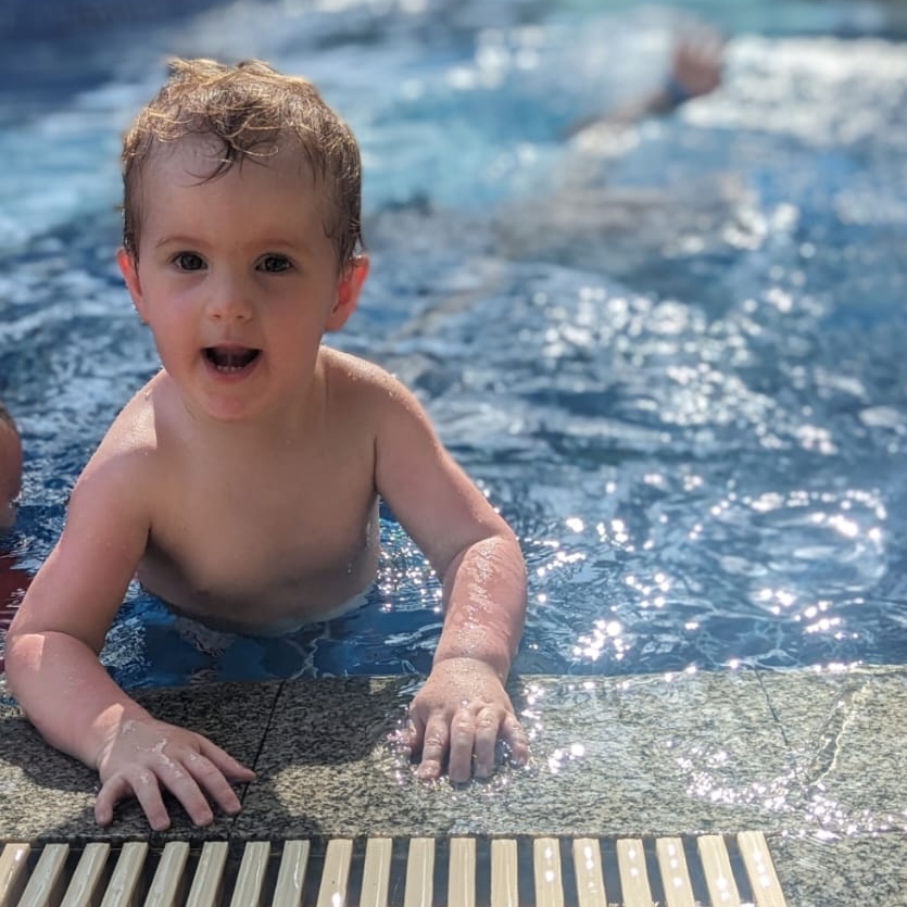 water babie swimmer rhys holding onto the edge of the pool